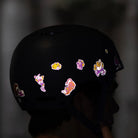 Reflektierende Aufkleber Künstleredition „C. Miller“ auf schwarzem Fahrradhelm der von einer Person getragen wird. Von REFLECTIVE Berlin.