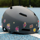 Reflektierende Aufkleber Künstleredition „C. Miller“ auf grauem Fahrradhelm auf einem Basketballplatz liegt. Von REFLECTIVE Berlin