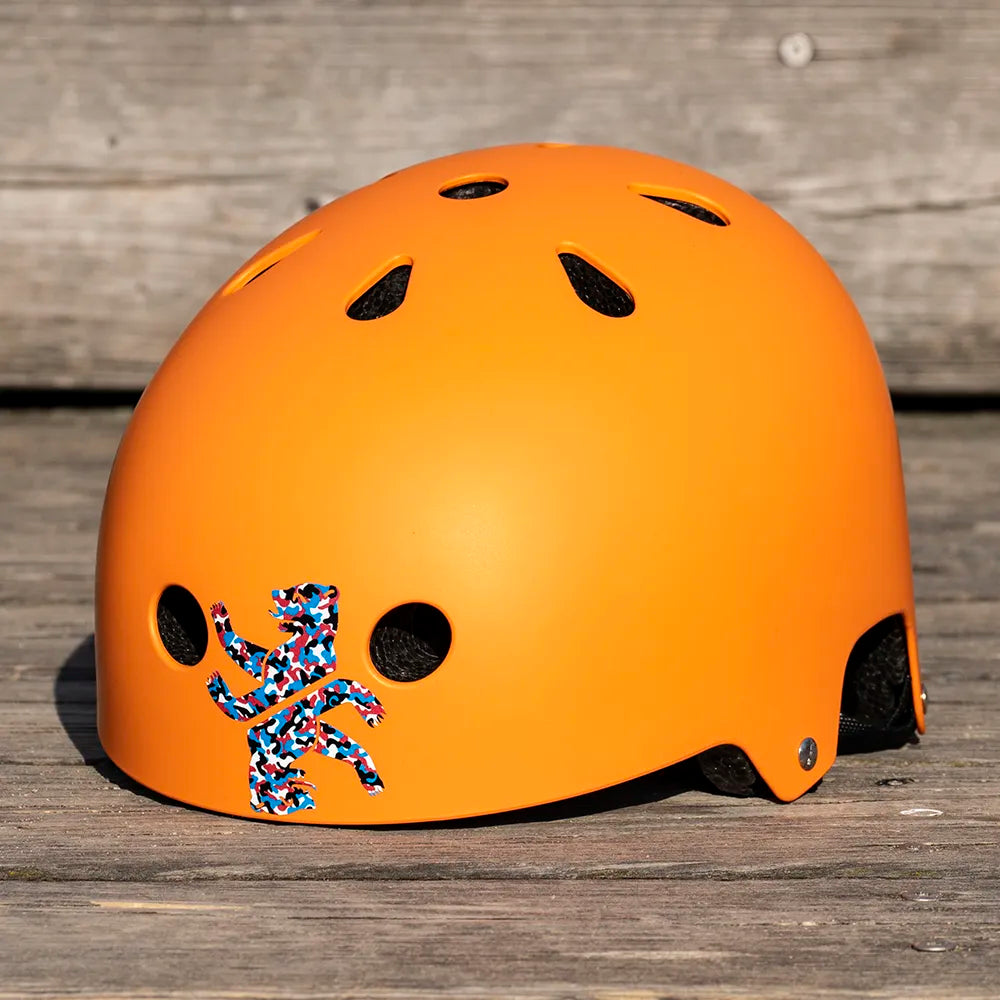 Zwei Reflektierende Aufkleber „Berliner Bär“ in Farbvariante „französisch Camo“ zugeschnitten auf orangem Fahrradhelm. Von REFLECTIVE Berlin.
