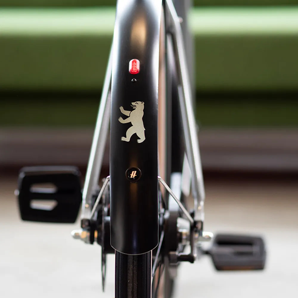 Reflektierender Aufkleber „Berliner Bär“ in Farbvariante „weiß“  auf schwarzem Fahrrad Schutzblech. Von REFLECTIVE Berlin.