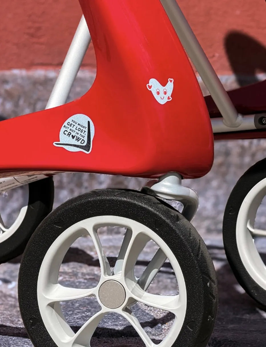 Detail von vorderem Teil eines roten byacre Rollators mit 2 Aufklebern