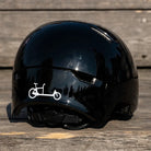 Reflektierender Aufkleber „Cargo“ in Farbvariante „weiß“ auf schwarzem Fahrradhelm vor unscharfem Hintergrund von REFLECTIVE Berlin.