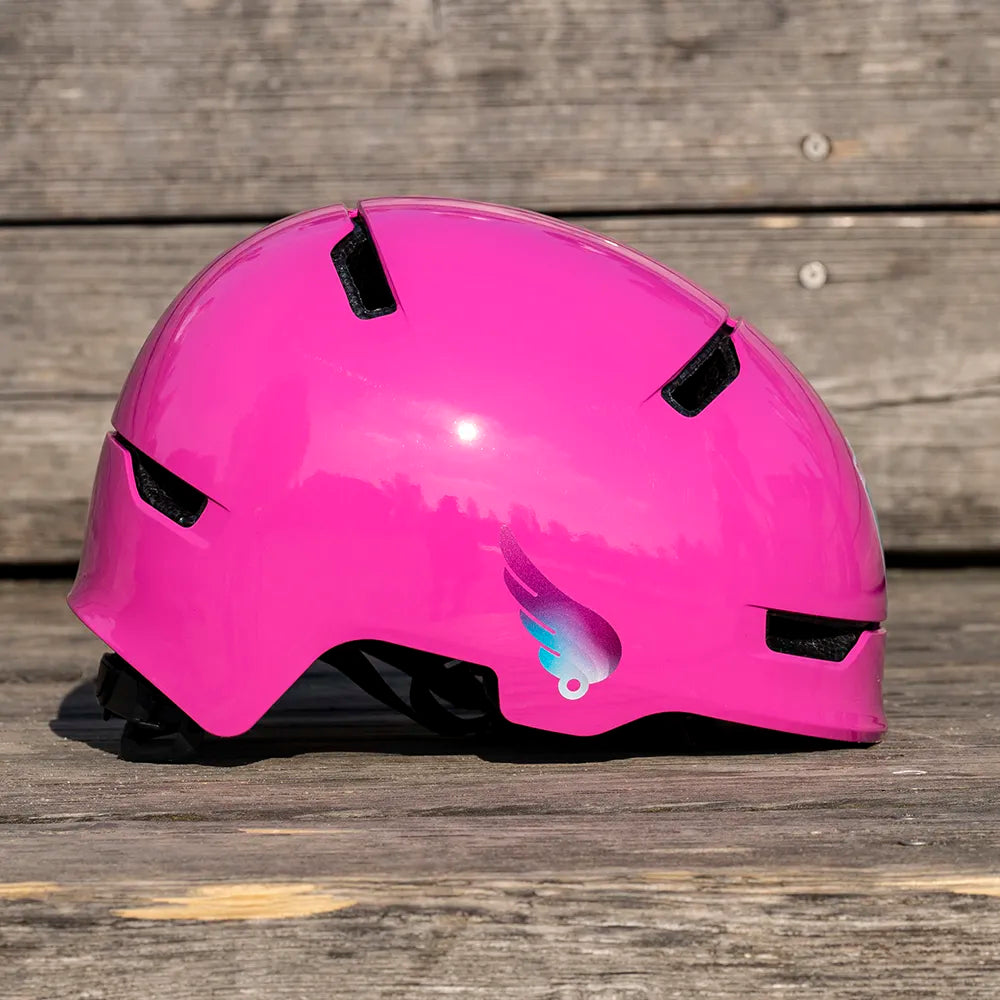 Reflektierender Aufkleber „Flügel“ in Detailaufname in Farbvariante „Lila“ auf pinkem Fahrradhelm vor Holzhintergrund von REFLECTIVE Berlin
