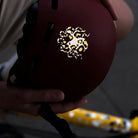 Reflektierender Aufkleber „Kraken“ in Farbvariante „Leo" auf einem roten Fahrradhelm vor einem verschwommenen Hintergrund von REFLECTIVE Berlin.