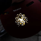 Reflektierender Aufkleber „Kraken“ in Farbvariante „Leo" auf einem roten Fahrradhelm von REFLECTIVE Berlin.