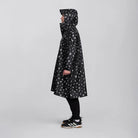 reflektierender Fahrrad Regenponcho in Farbvariante „Doodle“ getragen von einer Person, die im Profil vor weißem Hintergrund steht. Kollaboration von Bomance und REFLECTIVE Berlin.