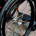 Reflektierender Speichen Aufkleber „Spokes“ in Farbvariante „Feuer“ auf den Speichen von einem Rollstuhl. Von REFLECTIVE Berlin.