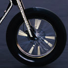 Reflektierender Speichen Aufkleber „Spokes“ in Farbvariante „weiß“ auf den Speichen eines rotierenden Laufrads zur Hervorhebung der Reflexion. Rahmen und Gabel des Fahrradrahmens sind mit reflektierenden XL Sticker „Flow“ in Farbvariante „weiß“ beklebt. Von REFLECTIVE Berlin.