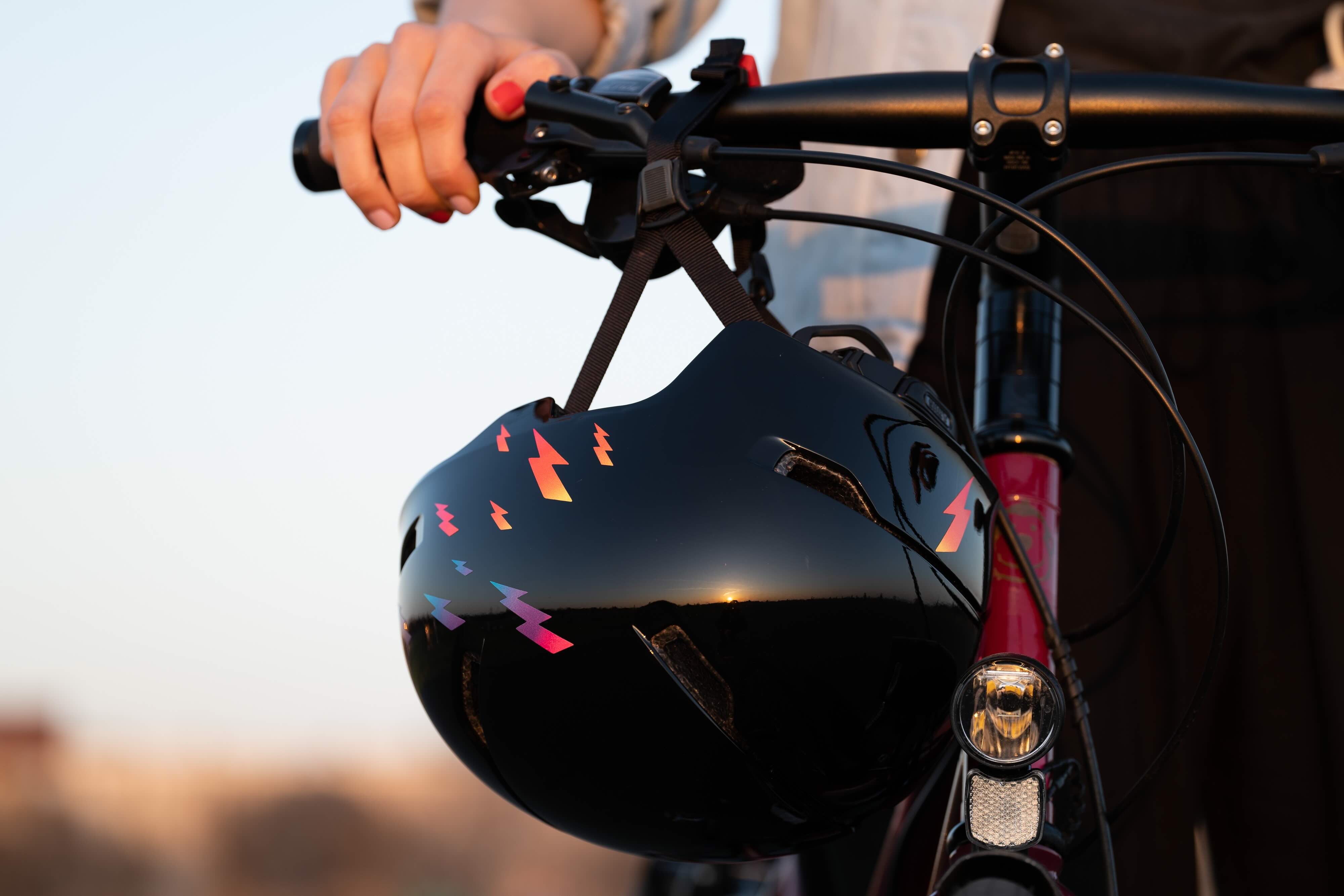 Rock Rain Rainbow von REFLECTIVE Berlin auf Fahrradhelm mit stark reflektierenden bunten Blitzformen für mehr Sichtbarkeit im urbanen Stil.