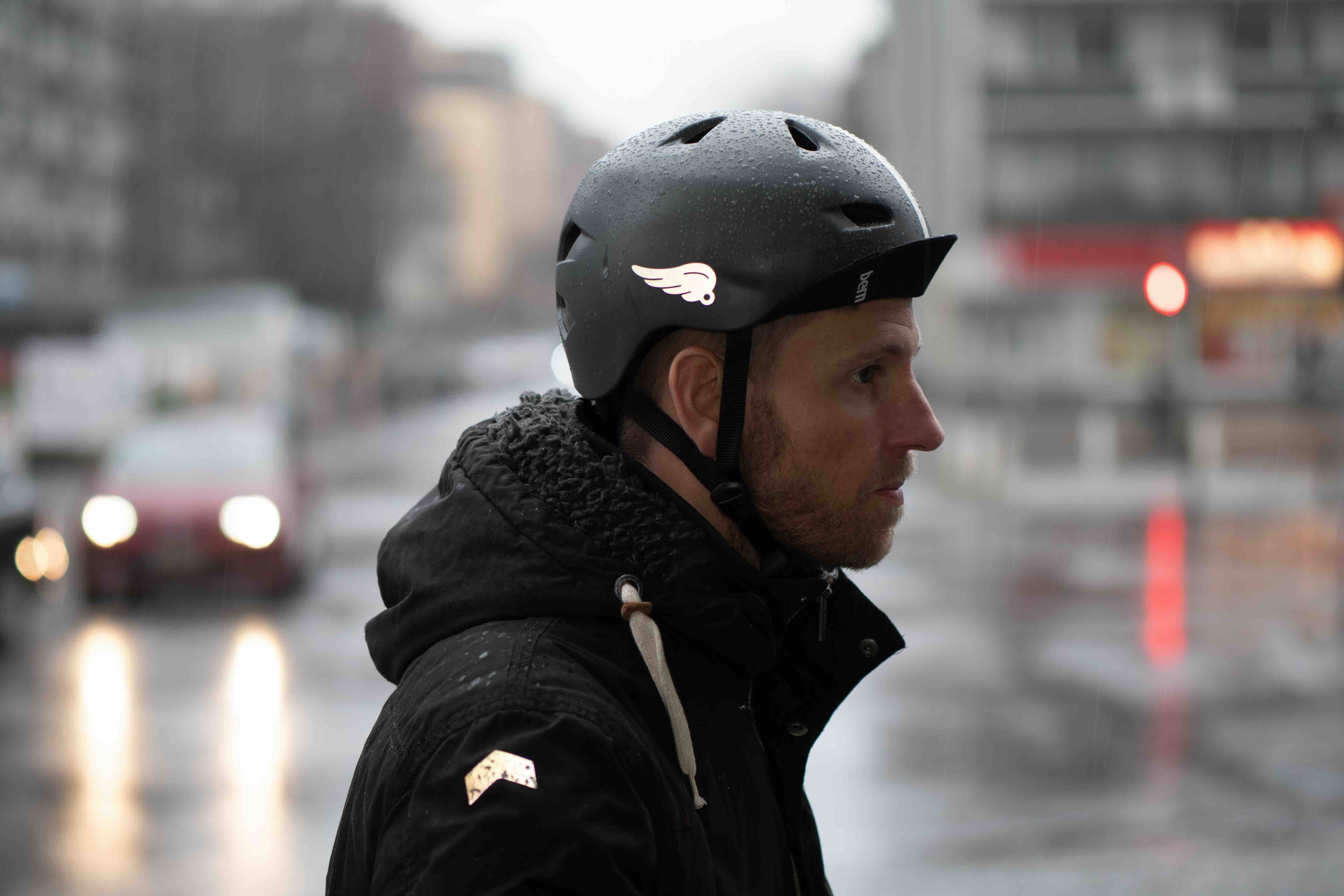 Wings Weiß von REFLECTIVE Berlin auf schwarzem Fahrradhelm mit stark reflektierendem Flügelmotiv für mehr Sichtbarkeit im urbanen Stil.