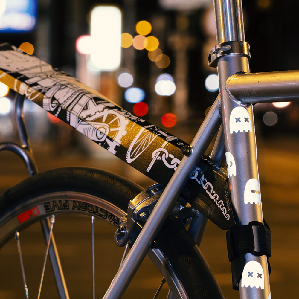 Detail Fahrrad im dunklen Stadtverkehr mit Stickerbomb Schutzblech und weißen leuchtenden Geister Stickern am Rahmen