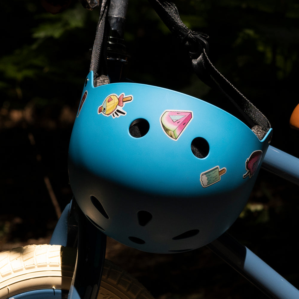 helmet hanging on bike handlebar, with reflective stickers 