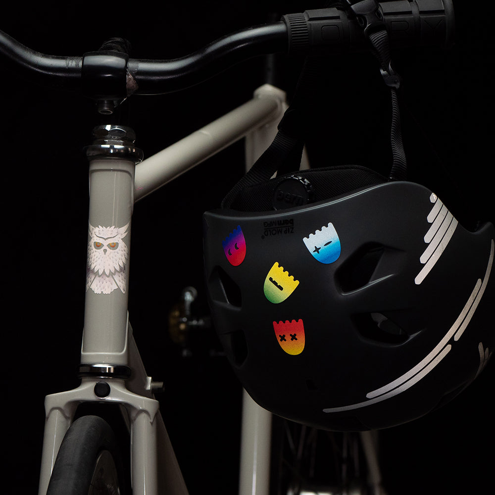 Fahrrad mit Helm am Lenker, im Dunkeln, mit reflektierenden Aufklebern 