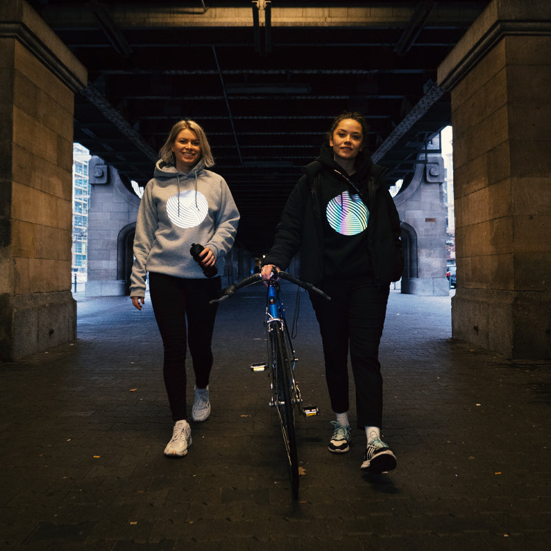 Reflektierende Sweater, sportlich, zwei Mädels spazieren unter Unterführung