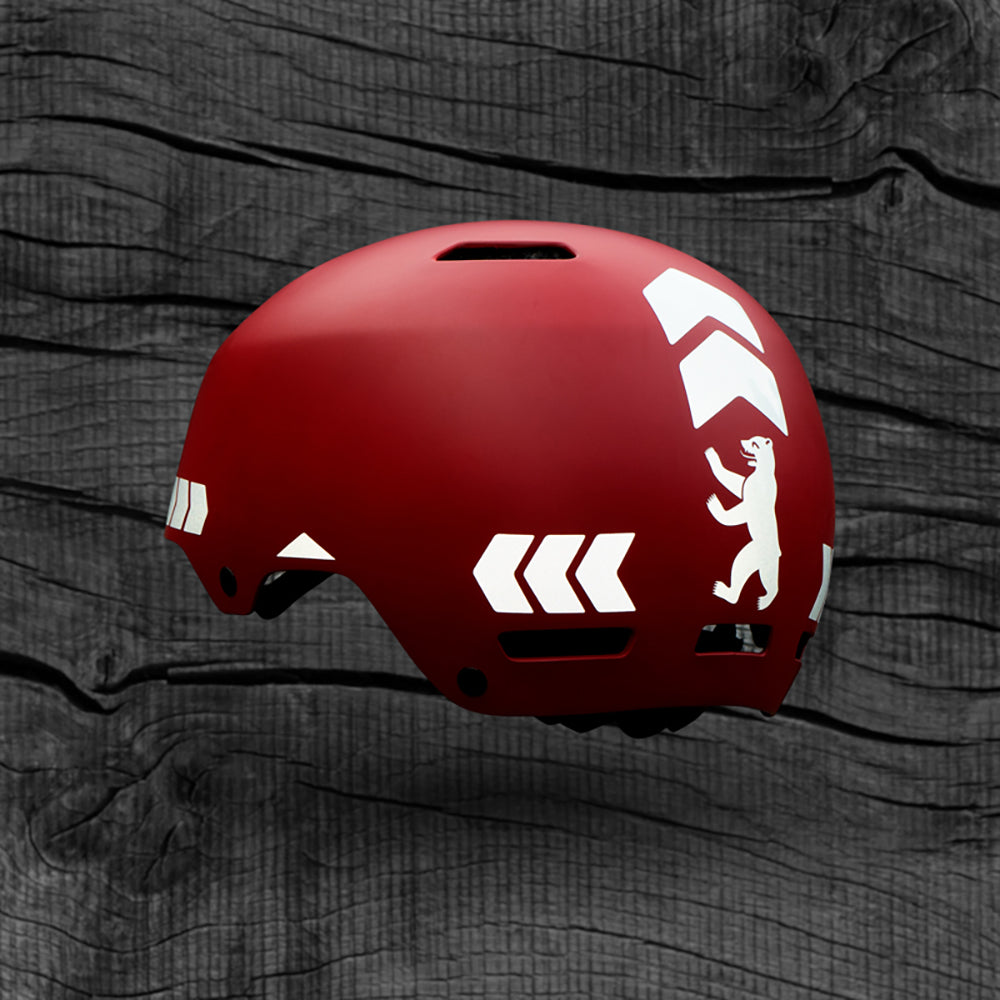 schwebender roter Helm mit weißen reflektierenden Stickern, Berliner Bär und Pfeile Chevrons