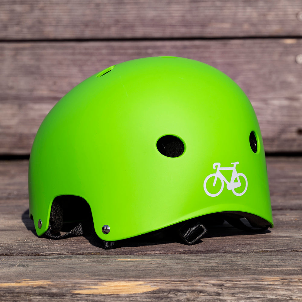 grüner Helm auf Holz, mit Fahrradaufkleber hinten