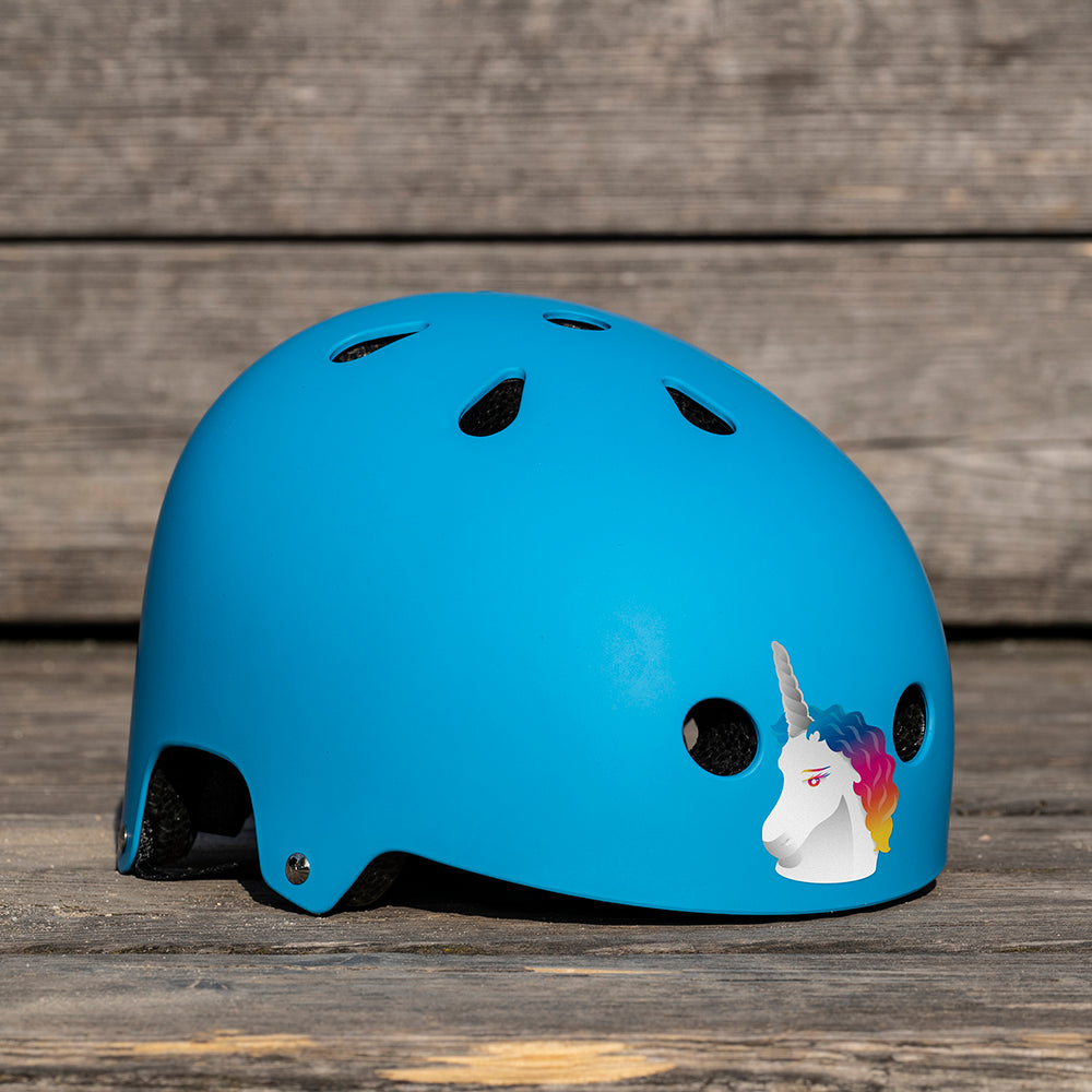 Blauer Helm auf Holzboden liegend, vorne ein Einhorn Sticker