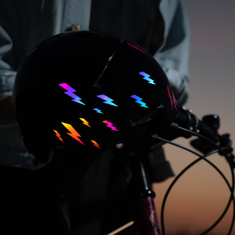 Bunte reflektierende Sticker (Blitze) auf einem Fahrradhelm.